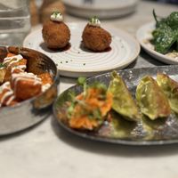 Mildred's sampler second course. va'atar padron peppers, pan-fried dumplings, ketchup harissa potato, crunchy coated risotto balls   at Mildreds - Covent Garden in London