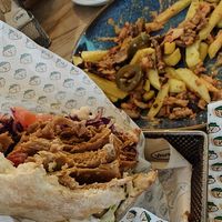 Loaded Fries in the background  💕 + big bite of Veganitas Berlin K'Bab, you'll get full! at Veganitas in Zurich