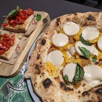 La diavola vegan pizza. Notice unmelted mozzarisella and a lot of bare crust. + Bruschetta. at Assaje in Trieste