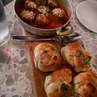 Puttanesca “Meatballs” ($18) - Lemon brown butter sauce, capers, kalamata olives, roma tomatoes, “mozzarella,” parsley garlic knots at Coletta in New York City