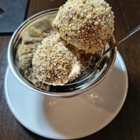 Mozart Eisknödel
Hazelnut-chocolate ice cream balls filled with marzipan, pistachio cream covered in caramelised hazelnut crumbs. at Tisch in Vienna