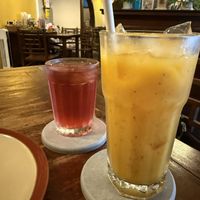 Mango passion fruit juice and complimentary iced tea in the background   at Anotai in Bangkok