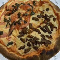 Pizza artesanal con muzza de maní y castañas de caju. Mitad capresse mitad panceta. Excelente 🍕  at Tropicalia Vegan House in Montevideo