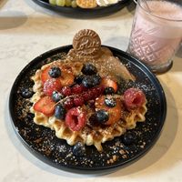 Vegan waffle with fresh berries and lotus cream accompanied by the Pink super drink  at Universe Cafe in Mannheim