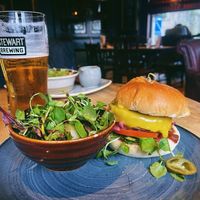 Vegan burger with pickled onions and jalapeños, vegan cheddar, tomato slice, and salsa. at The Conan Doyle in Edinburgh