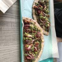 Zesty pesto (contains pepita seeds), no cheese, pulled jackfruit with housemade bbq sauce (gf), 
Green bell pepper  , red onions, pesto (contains seeds) , housemade almond Parmesan at Florish in Tampa