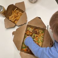 The orange cauliflower with tofu fried rice in the main box. Peanut butter parfait in the small cup    at Native Foods - Lakeview in Chicago