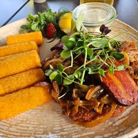 Schnitzel 'Holzfäller' topped with braised onions, served with croquettes, horseradish and vegan bacon (18.9) at Haus Am Park in Bad Soden-salmuenster