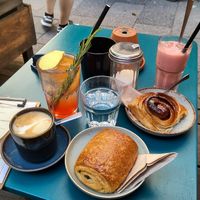 Pain au chocolat, cinnamon roll, flat white, blood orange lemonade, pink velvet latte on ice at Cafe Lozzi in Munich