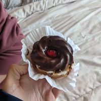 Vegan "swirl" donut with whipped cream middle, chocolate frosting on top, and cherry jam at Haven On Earth Bakery & Deli in Reno