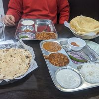 Dinner thali with black lentils and chickpea curry (front) chholay bhature plate (back right) at Satya Asha Veggie Food World in Surrey