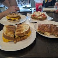 Left back: vegan breakfast sandwich on everything bagel, left front: vegan BF on sourdough, right back: vegetarian avocado toast w/feta (dairy), right front: vegan spanakopita at Koupa Espresso Bar in Haddon Township