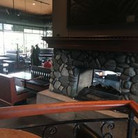 View of the restaurant interior from the lounge with its central fireplace. at Cactus Club Cafe in Nanaimo