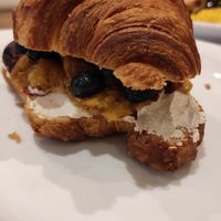 Croissant with almond cottage cheese blueberries and peach at Karma Organic Coffee in Krakow