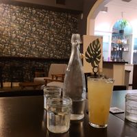 Bottled ice water and glass of house made rosemary lemonade. at Botanical Plant-Based Fare in Charlottesville
