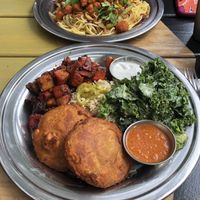 (Bottom) Chickpea cutlet plate with ginger molasses glazed root vegetables, kale in tahini sauce, coconut yogurt, tomato chutney, served over brown rice (Top) Indo Chinese noodles  at The Sudra in Portland