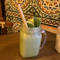 Green smoothie with fresh orange juice and frozen fruit   at Meet Vegano in Malaga