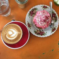 Almond latte and a vegan Boston raspberry bun at Queen Sally's Diamond Deli in Wellington