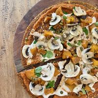 Pizza! Tasted great! Raw base, then tomato sauce, cheese, pumpkin, capers, mushrooms and herbs. Pretty sure the base had quite a long ingredient list which is unnecessary 🧐   at Alchemy in Ubud