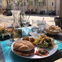 Beautiful vegan burger served with sautéed potatoes, salad and a Provençal tomato  at Le Panier Marseillais in Marseille
