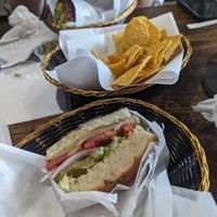Foreground: build your own sandwich + turky with red onions, lettuce, tomatoes, pickles on rosemary foccacia. Background: chickpea curry in a nori wrap.  at Royal Health World Retail & Cafe in Atlanta