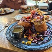 Chimichanga with tacos and a veggie burger in the background  at Penelope's Vegan Taqueria in Chicago