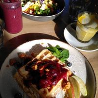 Foreground: belgian waffle with plum sauce and other toppings, background: Shakshuka (?) at Easy Peasy in Berlin