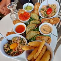 Vegan Tapas (for two people) with Tabbouleh and leafy salad, dumplings, marinated peppers, various dips, and something fried (bottom right). Not on the photo: small basket of white at Le Sunset-Nice in Nice