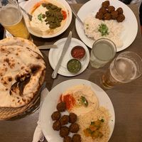 several dishes with pita bread and beer at Hummus Bar - Oktober in Budapest