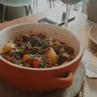 Patatas asadas y chorizo vegano ecológico gallego con queso vegano fundido y chimichurri at Distrito Vegano Invernadero in Madrid