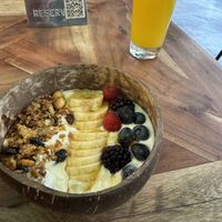 Yogurt bowl with orange juice   at Distrito Vegano Invernadero in Madrid
