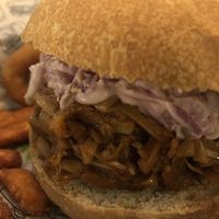 Hamburguesa de "pulled pork" con barbacoa, fries de moniato y aros de cebolla de acompanyamiento 10€  at La Loncheria Bcn in Barcelona