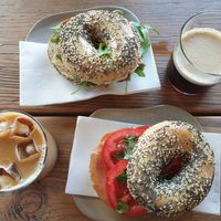 Iced latte $7.00, Hummus, Caramalised Onion+Rocket everything bagel $12.00, Nitro Coffee $7.00, Ham, Tomato+Basil everything bagel $12.00 at CBCB & ODFUB in Brunswick