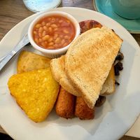 Full vegan breakfast, including potato bread, hash browns, baked beans, vegan sausages, mushrooms and a grilled tomato at Snax Cafe in Edinburgh