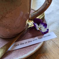 Coffee with lovely message, flower and spoon  at VIBE Plant Based Cafe & Restaurant in Douglas