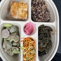 Tofu, grains, zoodles, greens, pickled onions, and potato salad   at Bloom in Seattle