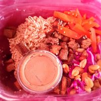 Peanut bowl in a takeaway box with sauce on the side at IRIE in San Juan Del Sur