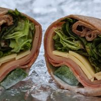 Yves salami, turkey, and ham slices, lettuce, bell peppers, Vegenaise, olive oil, vinegar, and Chao cheese on a whole wheat tortilla at Down to Earth  - Store and Deli in Kapolei