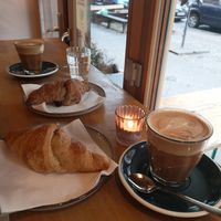Oat flat whites, choc croissant foreground, jam background at Croissanterie in Berlin