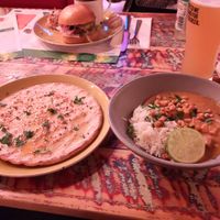Vegan roasted aubergine massaman curry with a side of garlic & chilli flatbread. Vegan Beyond cheese burger behind. at Lounges - Condado Lounge in Devizes