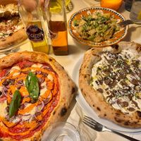 Various pizzas and Caesar salad at Al Catzone Pizza Napovegana in Berlin