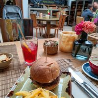 Burger with fries included, cappuccino with oat milk on the right at The Giri Café in Ibiza