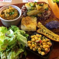 composed plates with different delicious food : cake, vegetables pancakes with beet emulsion, chickpeas, greens, brown rice, lentil puree. Everything vegan at Mariposas in Marseille