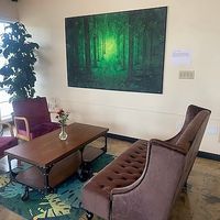 Beautiful vibrant green tree art and comfy velvet couch and chairs at Cup & Crêpe in Everett