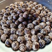 Dessert laddus with local ragi flour, palm jaggery, coconut oil, and sesame seeds. at Sadhana Forest Seva Kitchen in Auroville