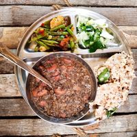Lunch platter with local organic brown rice, beans, vegetable curry, and salad.  at Sadhana Forest Seva Kitchen in Auroville