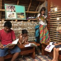 Reading with friends on Saturday evening potluck at Sadhana Forest Seva Kitchen in Auroville