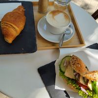 Orange croissaint, oat cappucino and tofu bagel at Robert Capa Café in Budapest