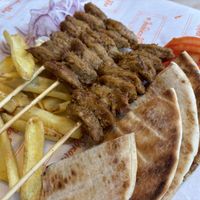 Vegan souvlaki with fries, pita, grilled onion, and fresh tomato. Unfortunately no greens.  at Ladokolla  in Kefalonia