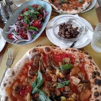 Marinara and vegetable vegan pizza with tomato onion salad with olives at La Napoletana in Taormina